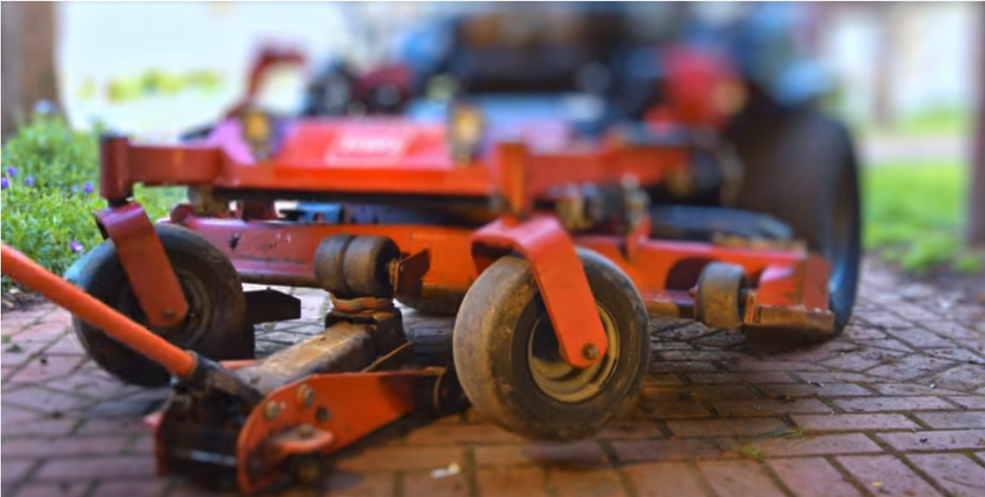Zero turn mower lifted with a jack to access the front wheel